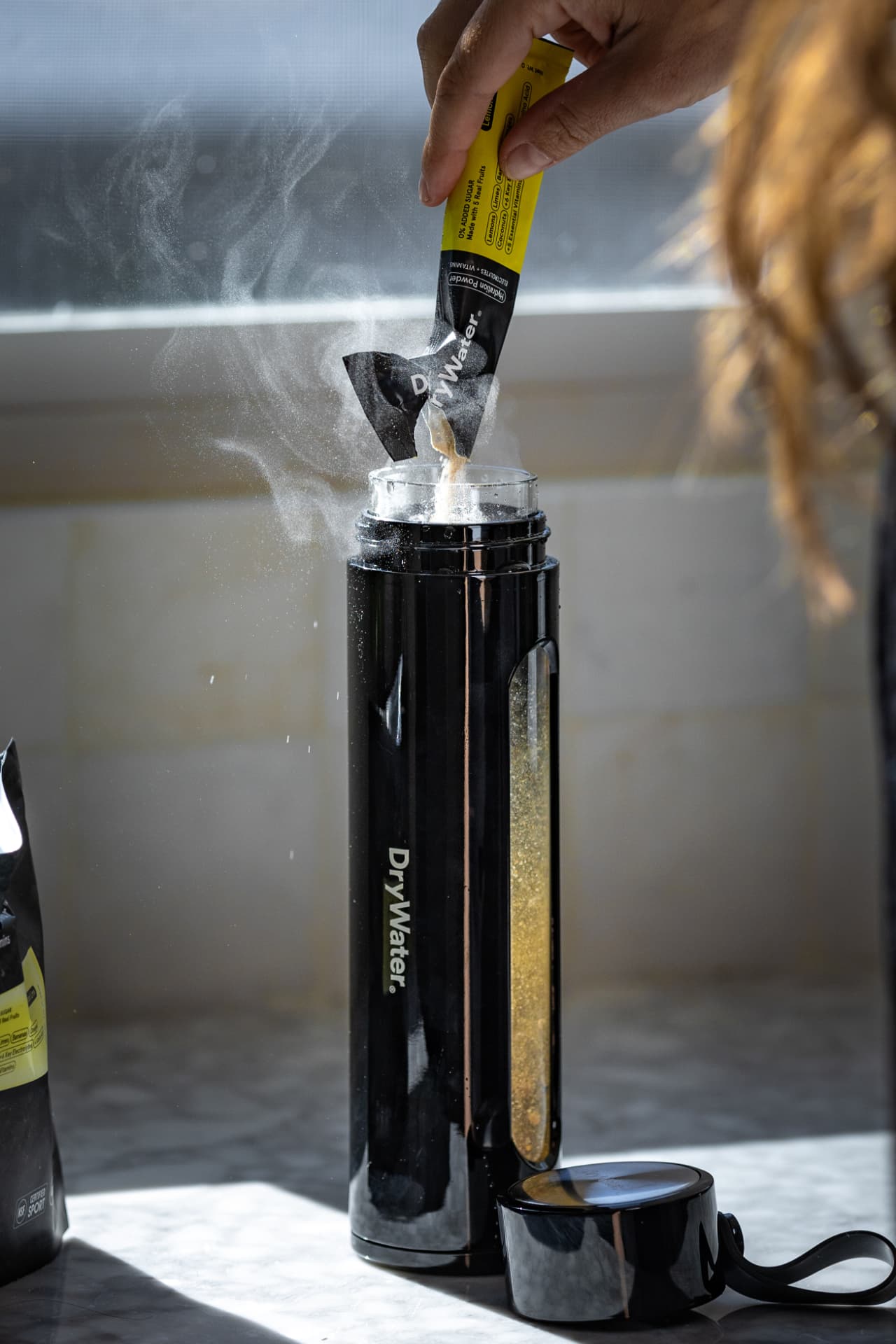 DryWater hydration powder being poured into a shaker bottle