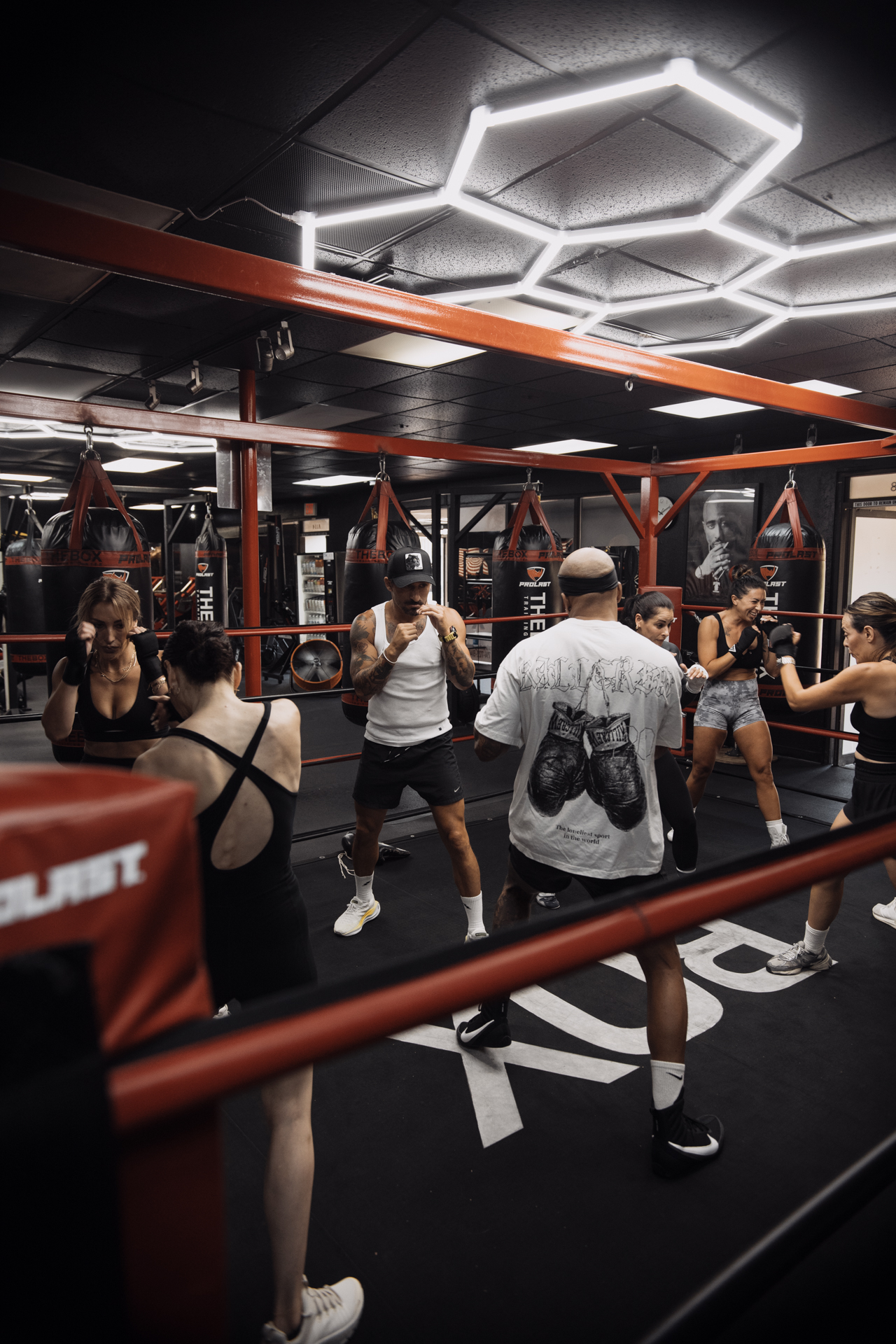 Boxing class training together inside a red-roped ring